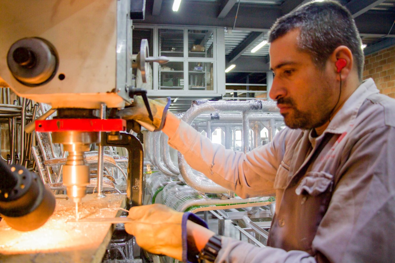 Trabajador con protector auditivo personalizado en ambiente industrial para evitar problemas auditivos por mal uso.
